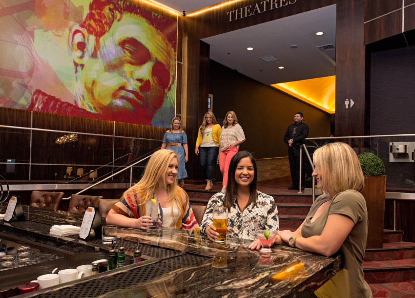 three women sitting at the bar located at the luxe.